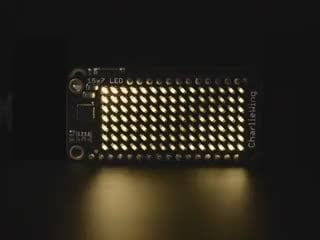 Video of a Adafruit 15x7 CharliePlex LED Matrix FeatherWing - waves of Warm White LED moving across the board. 