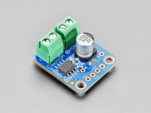 Angled shot of a blue, square-shaped DC motor driver breakout with green pre-soldered terminal blocks.