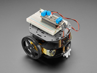 Angled shot of three-layer round robot in black metal with Feather plus motor featherwing connected to motors.