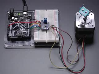Video of a Adafruit DRV8833 DC/Stepper Motor Driver Breakout Board connected to a half sized white board powering a stepper motor with a adabot head spinning on it. 