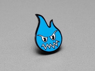 Angled shot of an enamel pin resembling an angry blue smoke monster character.