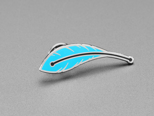 Angled shot of an enamel pin resembling a blue feather