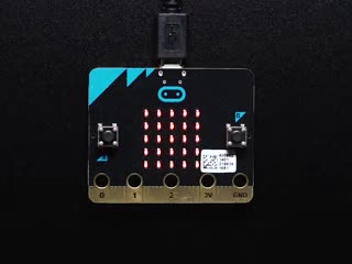 Top down view of a BBC micro:bit. "HELLO" scrolling through the display. 