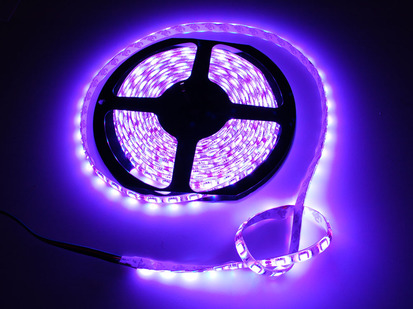 Spool of flexible LED strip lit up purple