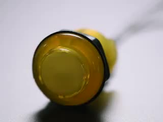 Video of 30mm translucent yellow LED arcade button flashing on and off.