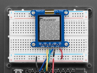Top down view of a Adafruit SHARP Memory Display Breakout connected to a half-sized white breadboard. 