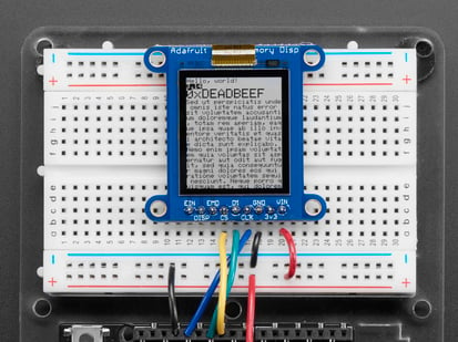 Top down view of a Adafruit SHARP Memory Display Breakout connected to a half-sized white breadboard. 
