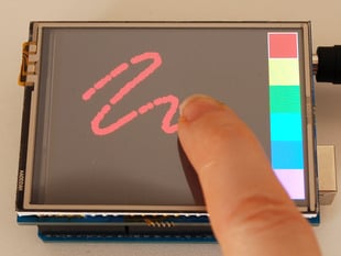 Still image of a white finger drawing wiggly line on a 2.8" TFT Touch Shield for Arduino.