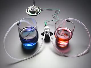 Peristaltic Liquid Pump moving liquid from a red cup to a blue cup