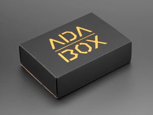Angled shot of a black box with Yellow "ADABOX" texted logo.