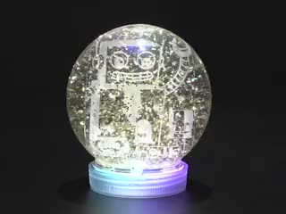 Snow globe with sparkly flakes swirling around, a ring of RGB LEDs in the base animate in a rainbow swirl.
