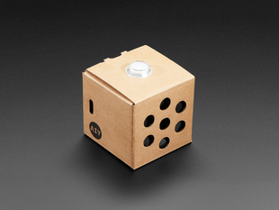 Angled shot of assembled cardboard cube with white button on top.