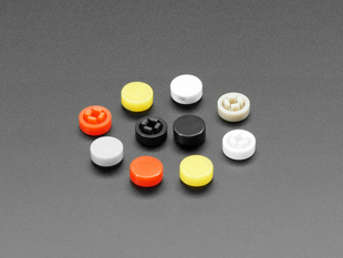 Angled shot of 10 plastic button caps colored reddish-orange, yellow, white, and black.