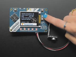 Video of a turquoise polished finger pressing the button on a TensorFlow Lite for Microcontrollers Kit. Speaker output showing "YES" and "NO"