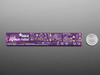 Back view of Adafruit PyRuler, a purple electronic ruler, next to US quarter for scale. 