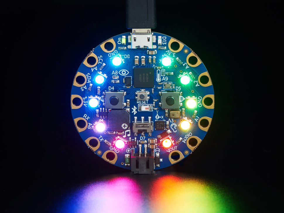 Top view of Circuit Playground Bluefruit glowing rainbow LEDs.
