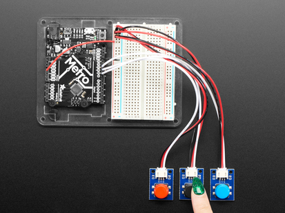 STEMMA Wired Tactile Push-Buttons connected to a half sized white breadboard