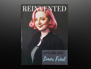 Front cover of Reinvented Magazine - Issue 2: LADIES WHO HACK - Limor Fried. A white woman with chin-length, curled pink hair and a lip ring faces the reader. She wears a black-and-white striped top under a black jacket. Her facial expression reads confident and assured. 