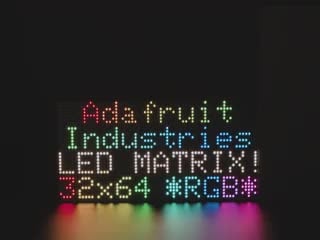 LED RGB matrix 12" x 12" with "Adafruit Industries LED Matrix" text showing, and LED acrylic slowly covering to make it nicely diffused