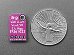 Back shot of a black Adafruit MiniBooster next to a US quarter for scale. 