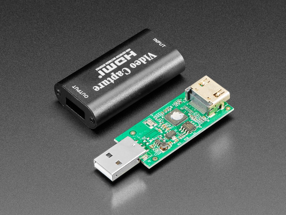 Video capture adapter with the shell removed next to it with focus on the USB 2.0