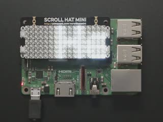 Top down view of aPimoroni Scroll HAT Mini for Raspberry Pi connected to a Raspberry Pi. Reads "Hello World!" scrolling across the display. 