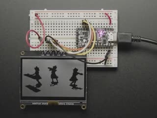 Adafruit SHARP Memory Display Breakout connected to a half-sized breadboard and a microcontroller. The breakout board plays a black and white animation video of black figures playing violins and a keyboard.