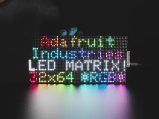 LED RGB matrix 10.2" x 5.1" with "Adafruit Industries LED Matrix" text showing, and LED acrylic slowly covering to make it nicely diffused