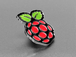 Angled shot of an enamel pin resembling a raspberry