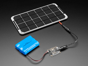 Angled shot of a Adafruit Universal USB / DC / Solar Lithium Ion/Polymer charger connected to a solar panel and 3 AAA batteries. 