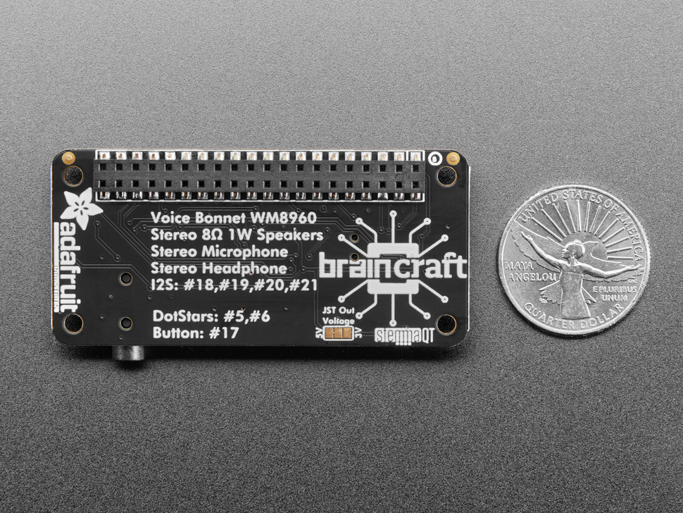 Back of black, rectangular audio breakout board next to US quarter for scale.