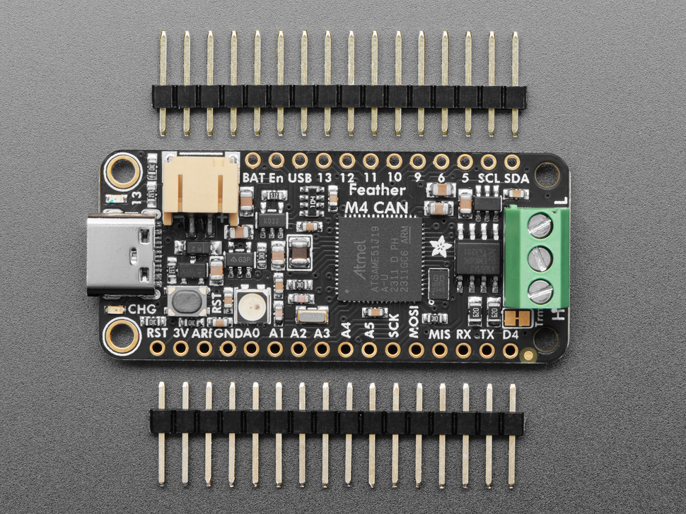 Top down view of a Adafruit Feather M4 CAN Express with ATSAME51 surrounded by pin headers. 