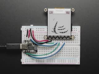 Video of a 1.54" tri-color eInk display assembled on a breadboard with jumper wires and a QT Py. Friendly snake in white-and-red, Blinka, appears on the display.