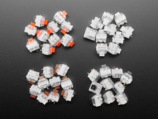 Top down view of four piles of Kailh key switches in Red, Black, Brown, and Black variations.