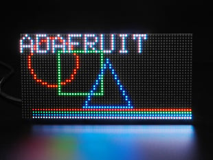 Front on view of an RGB Matrix panel displaying "Adafruit" along with geometric shapes.