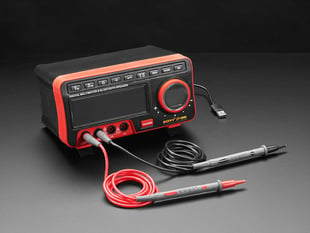 Angled shot of digital multimeter with two test lead probes.