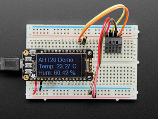 Top view of DHT20 sensor wired to a breadboard with an FeatherWing OLED display. The OLED shows the data from the temperature-humidity sensor.