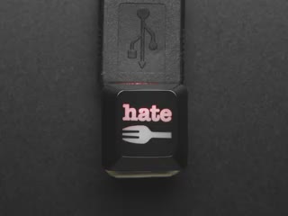 Top view video of black H8 fork logo keycap connected via USB cable. Various colors emit through the logo.