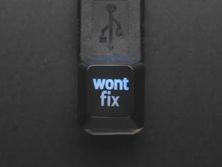 Top view video of black wontfix keycap connected via USB cable. Various colors emit through the logo.