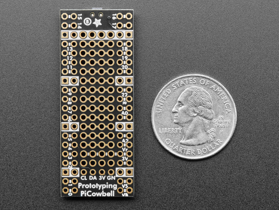 Overhead shot of bottom of long, skinny prototyping breakout board next to US quarter for scale.