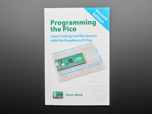 Front cover of technical book: "Programming the Pico. Learn Coding and Electronics with the Raspberry Pi Pico." Cover art is an angled photograph of a long green rectangular microcontroller assembled into a half-size breadboard.