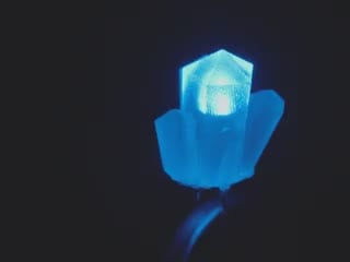 Rotational video of blue-glowing crystal-shaped LED.