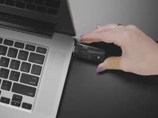 Video of a USB booster cable plugged into a laptop. A white hand flicks a switch on top of the booster, causing the display to report 9V to 12V.