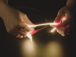 Video of a pair of white hands coiling and playing with a 300mm long warm white LED filament.