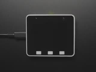 Overhead video of a small IoT-enabled microcontroller with color screen loading its bootup video. The bootup features a white screen, the text: "Espressif", 
