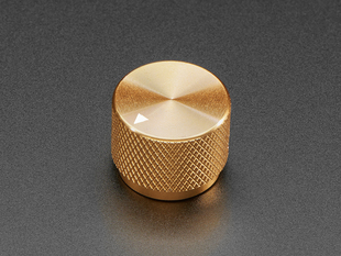Angled shot of a gold aluminum knob. A white triangle on top of the knob points at 7:00.
