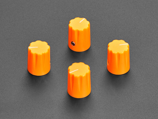 Angled shot of four orange micro knobs.