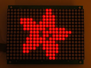 Red LED grid lit up with an adafruit logo