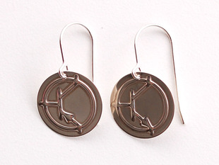 Close up of silver earrings. One  showing an NPN symbol and the other showing a PNP symbol