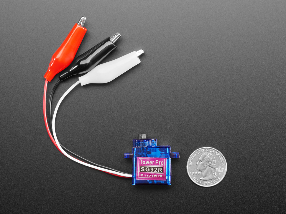 Overhead shot of a blue micro servo with red, black, and white alligator test clip leads next to US quarter for scale.